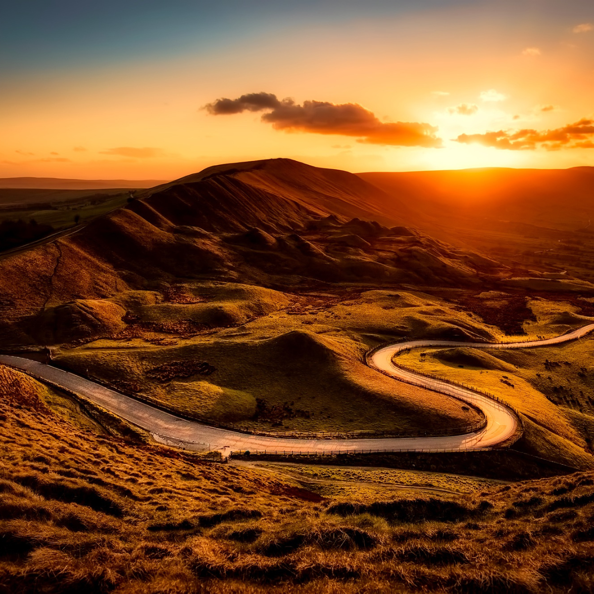 A winding road through sunlit hills at sunset, symbolizing the seeker’s path through uncertainty toward deeper truth.